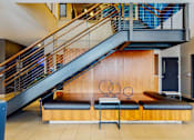 Thumbnail 9 of 27 - Lobby stair case with stylish seating underneath, wire railings on stairs