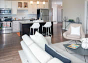 Thumbnail 4 of 27 - a living room and kitchen with a couch and a table