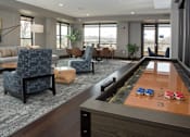 Thumbnail 24 of 27 - Community room with large circular table and many chairs, shuffleboard table