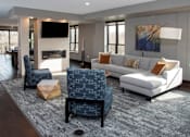 Thumbnail 22 of 27 - Community space with large sectional couch, fireplace and mounted flatscreen
