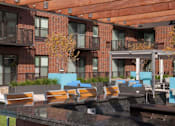 Thumbnail 15 of 27 - Outdoor community kitchen and bar with seating, balconies in background
