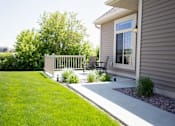 Thumbnail 16 of 27 - Private patio at Cascade Shores Townhomes with a paved walkway and a lush lawn.