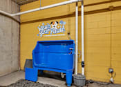 Thumbnail 22 of 24 - a blue trash can in front of a yellow wall