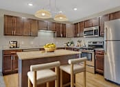 Thumbnail 1 of 24 - a kitchen with stainless steel appliances and an island with chairs