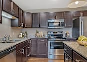 Thumbnail 3 of 24 - a modern kitchen with stainless steel appliances and granite counter tops