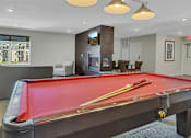 Thumbnail 16 of 24 - a red pool table in a living room with a fireplace