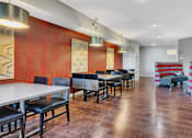 Thumbnail 17 of 24 - a dining room with tables and chairs in front of a red wall