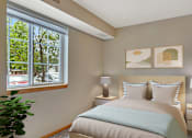 Thumbnail 7 of 11 - a bedroom with a bed and a large window