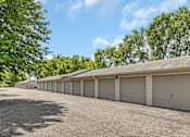 Thumbnail 10 of 11 - a row of garages in a parking lot with trees
