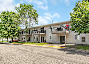 Thumbnail 3 of 11 - an apartment building with a street and trees in front of it