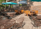 Thumbnail 33 of 34 - Outdoor community patio with umbrella tables and outdoor dining tables.