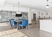 Thumbnail 27 of 40 - a kitchen and dining area with a marble island and blue chairs