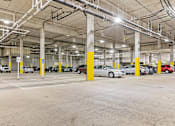 Thumbnail 34 of 40 - a parking garage with cars parked in it and yellow pillars