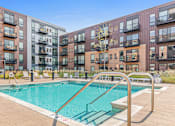 Thumbnail 19 of 40 - a swimming pool with an apartment building in the background