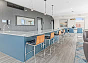 Thumbnail 12 of 40 - a communal bar with blue stools in a hotel lobby