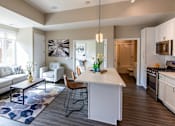 Thumbnail 9 of 40 - a living room and kitchen with a couch and a table