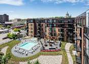 Thumbnail 17 of 40 - Stunning panoramic view from the balcony at Oxbo Urban Rentals. Large pool deck, outdoor lounge area, and St Paul skyline can be seen from the balcony.