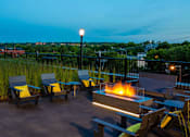 Thumbnail 21 of 40 - Outdoor fireplace at night with lounge chairs all looking out onto gorgeous St. Paul.