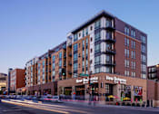 Thumbnail 1 of 40 - Exterior of Oxbo Urban Rentals with their large windows. Apartment units are located above a level of retail space, a restaurant on this level is New Bohemia.