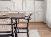 Thumbnail 52 of 58 - a dining area with a wooden table and rattan chairs and a white rug on the floor