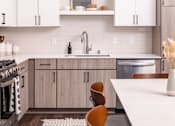 Thumbnail 6 of 58 - a kitchen with white cabinets and a white table and chairs