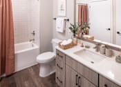 Thumbnail 18 of 58 - a bathroom with a white toilet next to a white bathtub and a white sink with a
