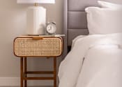 Thumbnail 15 of 58 - a nightstand with a lamp and a clock on it next to a bed