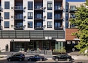 Thumbnail 1 of 58 - an apartment building with cars parked in front of it