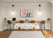 Thumbnail 24 of 58 - a meeting room with a long table with chairs around it and two lamps hanging from the ceiling