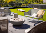 Thumbnail 39 of 58 - a seating area with a fire pit and chairs on a patio with a lawn in the background