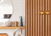 Thumbnail 27 of 58 - a bathroom with a wooden door and a white countertop with a white sink and a round