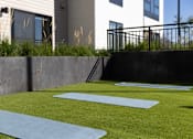 Thumbnail 38 of 58 - a home gym with synthetic grass and concrete walls