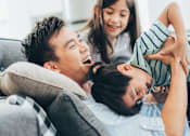 Thumbnail 4 of 34 - a man and a woman are sitting on a couch with a young boy and girl