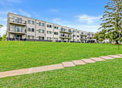 Thumbnail 34 of 34 - A large grassy area in front of apartment buildings.