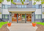 Thumbnail 29 of 34 - The front of a building with a glass door and windows.