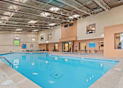 Thumbnail 21 of 34 - A large indoor swimming pool with a blue tiled bottom.