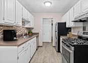 Thumbnail 3 of 34 - A kitchen with black appliances and white cabinets.