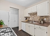Thumbnail 6 of 34 - A kitchen with white cabinets and a white fridge.