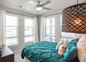 Thumbnail 10 of 42 - Furnished bedroom with twin bed, dark wood dresser and windows for natural light