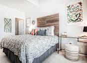 Thumbnail 5 of 42 - Furnished bedroom with king bed, wall art and attached private bathroom