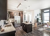 Thumbnail 2 of 42 - Open kitchen and living room with small center island, dark wood cabinets and granite countertops, furnished living room space