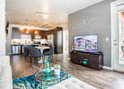 Thumbnail 8 of 42 - Living room attached to kitchen, with television, sectional couch and door leading to private patio