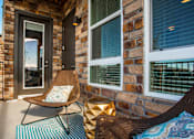 Thumbnail 13 of 42 - Private balcony with lounge chairs, railing, and door leading into apartment