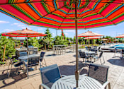 Thumbnail 18 of 42 - Circular four person tables with large red umbrellas next to outdoor pool