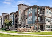 Thumbnail 41 of 42 - an apartment building with a green lawn and a sidewalk
