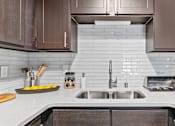 Thumbnail 5 of 29 - a white kitchen with wooden cabinets and a sink