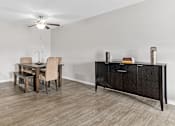 Thumbnail 8 of 29 - a dining room with a table and chairs and a kitchen with a cabinet