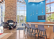 Thumbnail 13 of 29 - a lobby with a bar with chairs and a fireplace