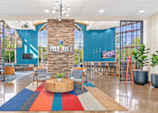 Thumbnail 11 of 29 - a lobby with a round table and chairs and a blue wall with a large window