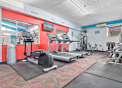 Thumbnail 17 of 24 - A gym with treadmills, exercise bikes, and other equipment.